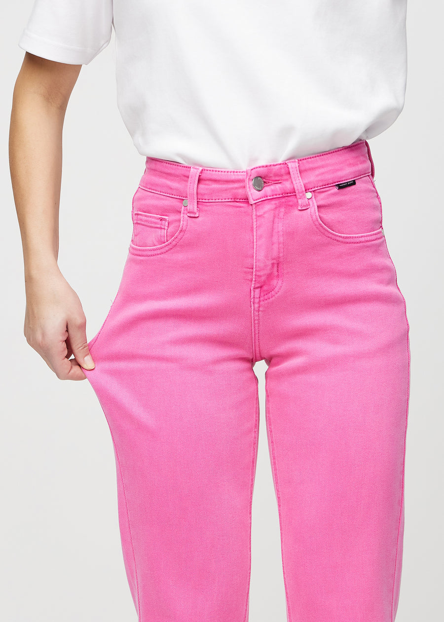 Regularjeans för kvinnor i ljusrosa, färgen Flamingos. En modell drar i tyget vid låret för att visa stretchen.
