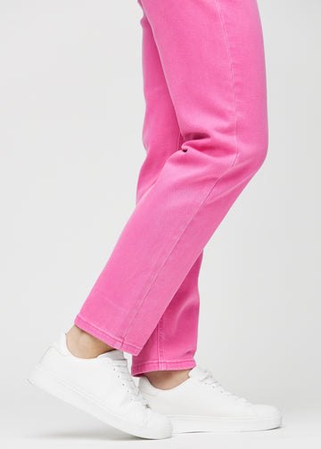 Regularjeans för kvinnor i ljusrosa, färgen Flamingos. Närbild vid anklarna på en modell, som visar de raka bensluten.