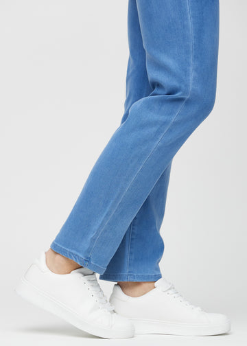 Regularjeans för kvinnor i blå, färgen Geraniums. Närbild vid anklarna på en modell, som visar de raka bensluten.