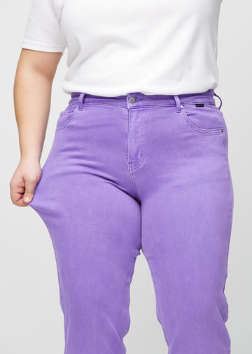 Regularjeans för kvinnor i lila, färgen Lavenders. En plus size-modell drar i tyget vid låret för att visa stretchen.