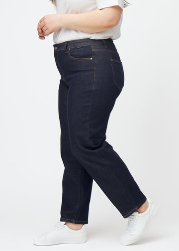 Djupt mörkblå denim jeans för kvinnor i färgen Midnights med regular passform sedd från sidan på plus size-modell.