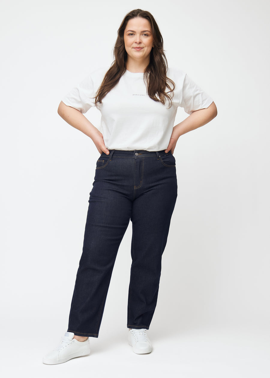 Helbild av plus size-modell i djupt mörkblå denim jeans för kvinnor i färgen Midnights med regular passform.