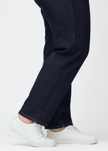 Djupt mörkblå denim jeans för kvinnor i färgen Midnights med regular passform sedd i närbild vid anklarna på plus size-modell för att visa det raka avslutet.