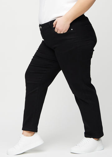 Regularjeans för kvinnor i svart, färgen Ravens. Från sidan på en plus size-modell.