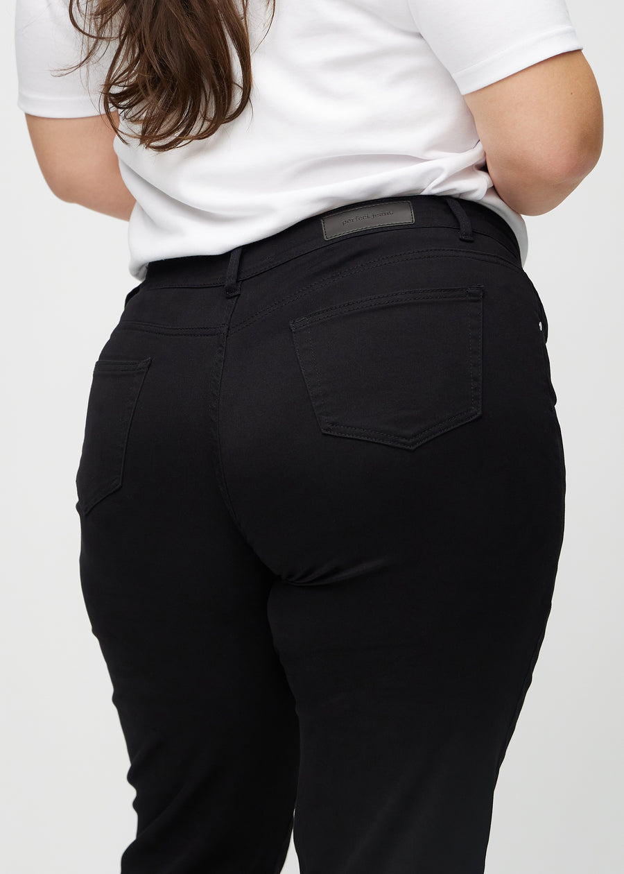 Regularjeans för kvinnor i svart, färgen Ravens. Närbild bakifrån på en plus size-modell, som visar passform och detaljer.