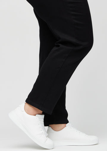 Anklarna på en plus size-modell, så att man kan se hur löst jeansen sitter i en Regular passform.