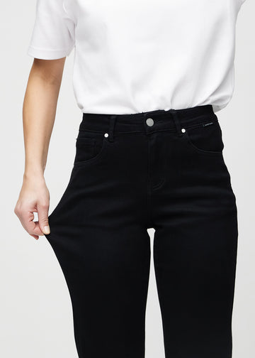 Regularjeans för kvinnor i svart, färgen Ravens. En modell drar i tyget vid låret för att visa stretchen.