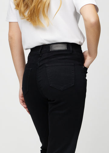 Regularjeans för kvinnor i svart, färgen Ravens. Närbild bakifrån på en modell, som visar passform och detaljer.