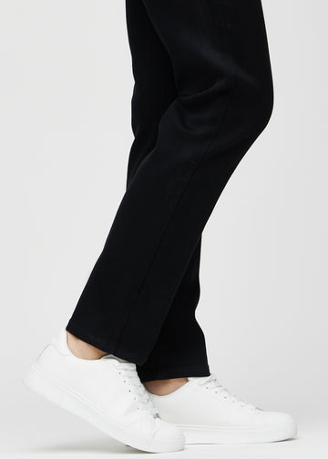 Anklarna på en modell, så att man kan se hur löst jeansen sitter i en Regular passform.