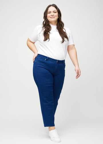 Regularjeans för kvinnor i mörkblå, färgen Royals. Helbild av en plus size-modell som bär jeansen.