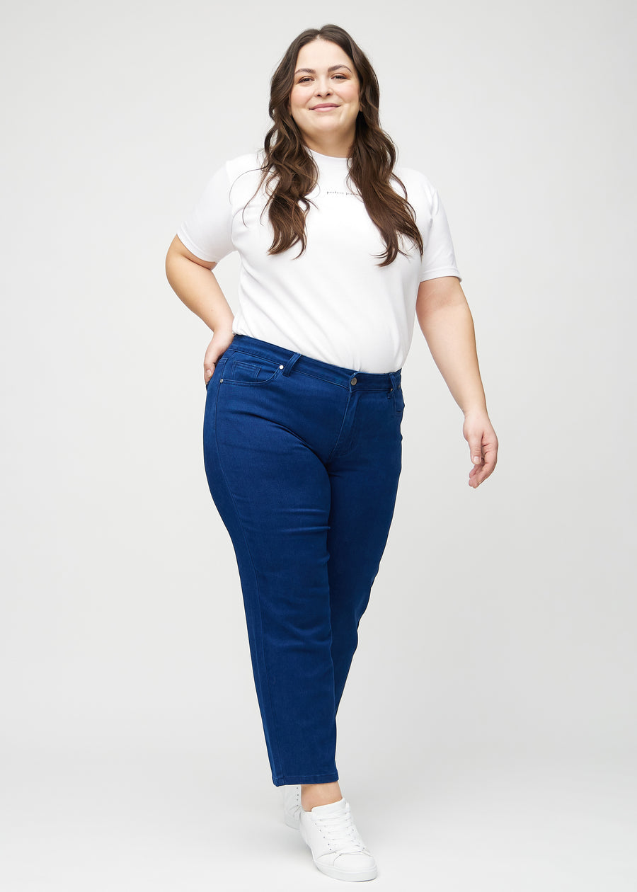 Regularjeans för kvinnor i mörkblå, färgen Royals. Helbild av en plus size-modell som bär jeansen.