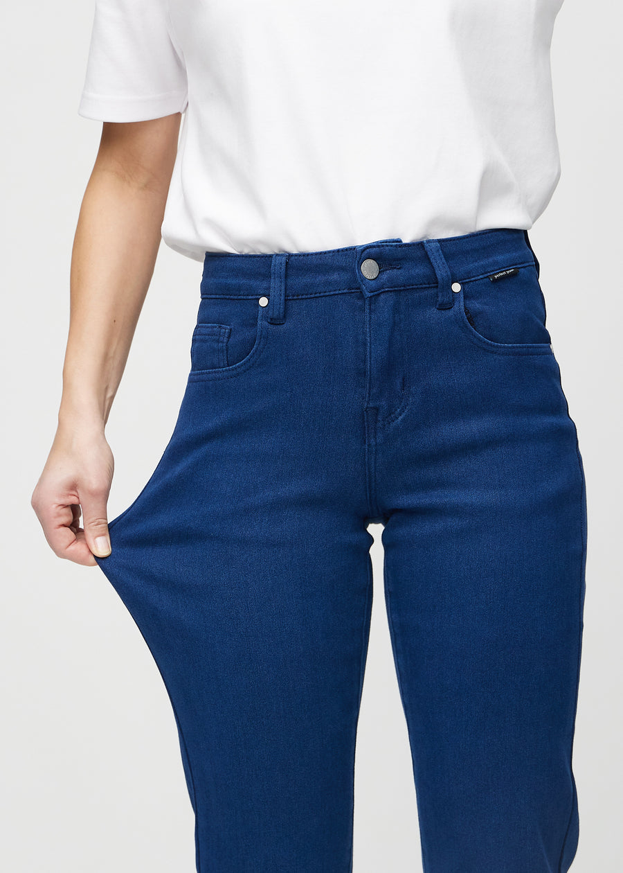 Regularjeans för kvinnor i mörkblå, färgen Royals. En modell drar i tyget vid låret för att visa stretchen.