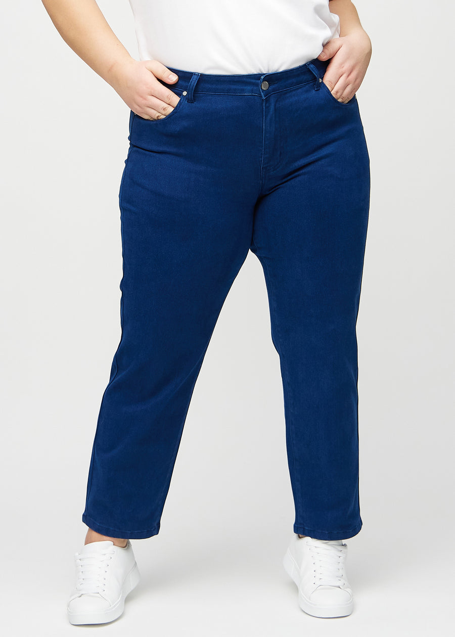 Regularjeans för kvinnor i mörkblå, färgen Royals. Framifrån på en plus size-modell, med klassiskt raka ben.