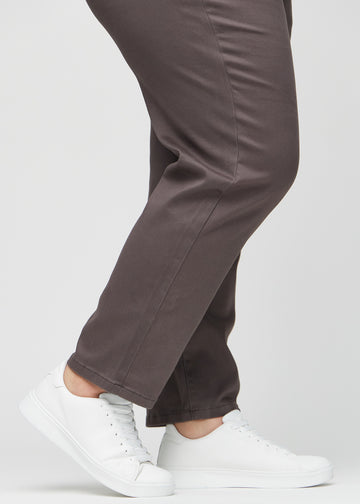 Regularjeans för kvinnor i gråbrun, färgen Thunders. Närbild vid anklarna på en plus size-modell, som visar de raka bensluten.