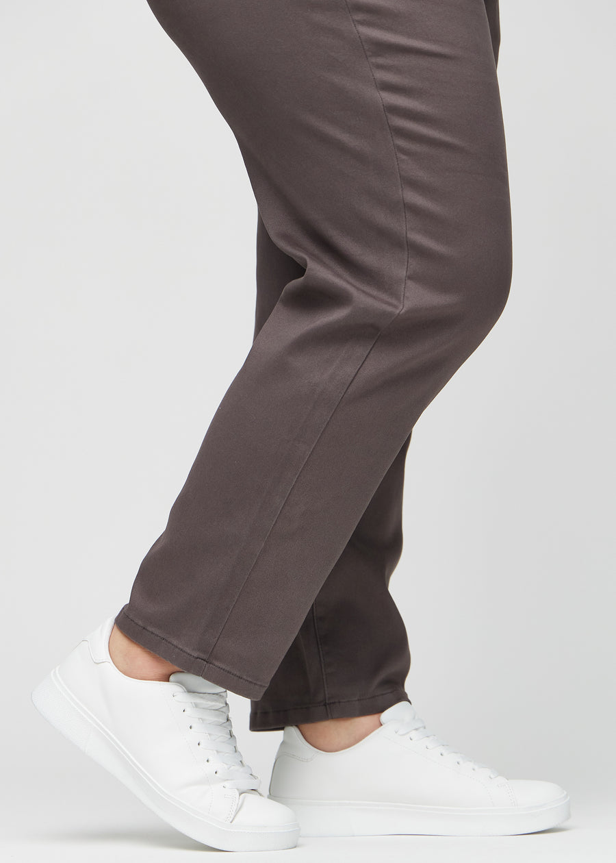 Regularjeans för kvinnor i gråbrun, färgen Thunders. Närbild vid anklarna på en plus size-modell, som visar de raka bensluten.
