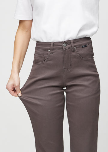 Regularjeans för kvinnor i gråbrun, färgen Thunders. En modell drar i tyget vid låret för att visa stretchen.
