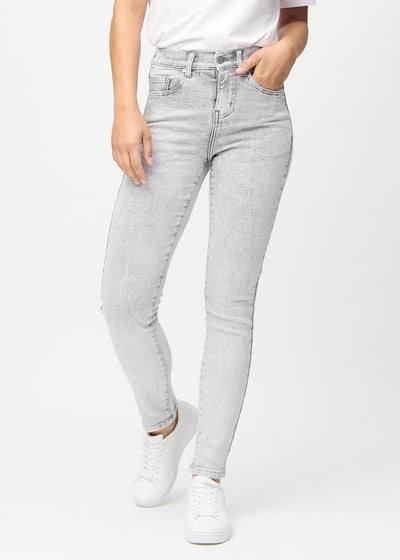 Skinnyjeans för kvinnor i ljusgrå, färgen Ashes. Framifrån på en modell, med nära passform runt benen.