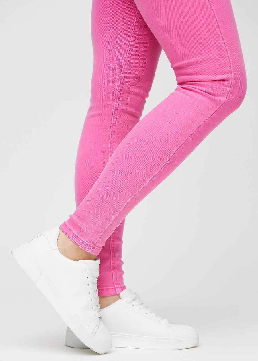 Skinnyjeans för kvinnor i ljusrosa, färgen Flamingos. Närbild vid anklarna på en modell som visar de åtsittande bensluten.