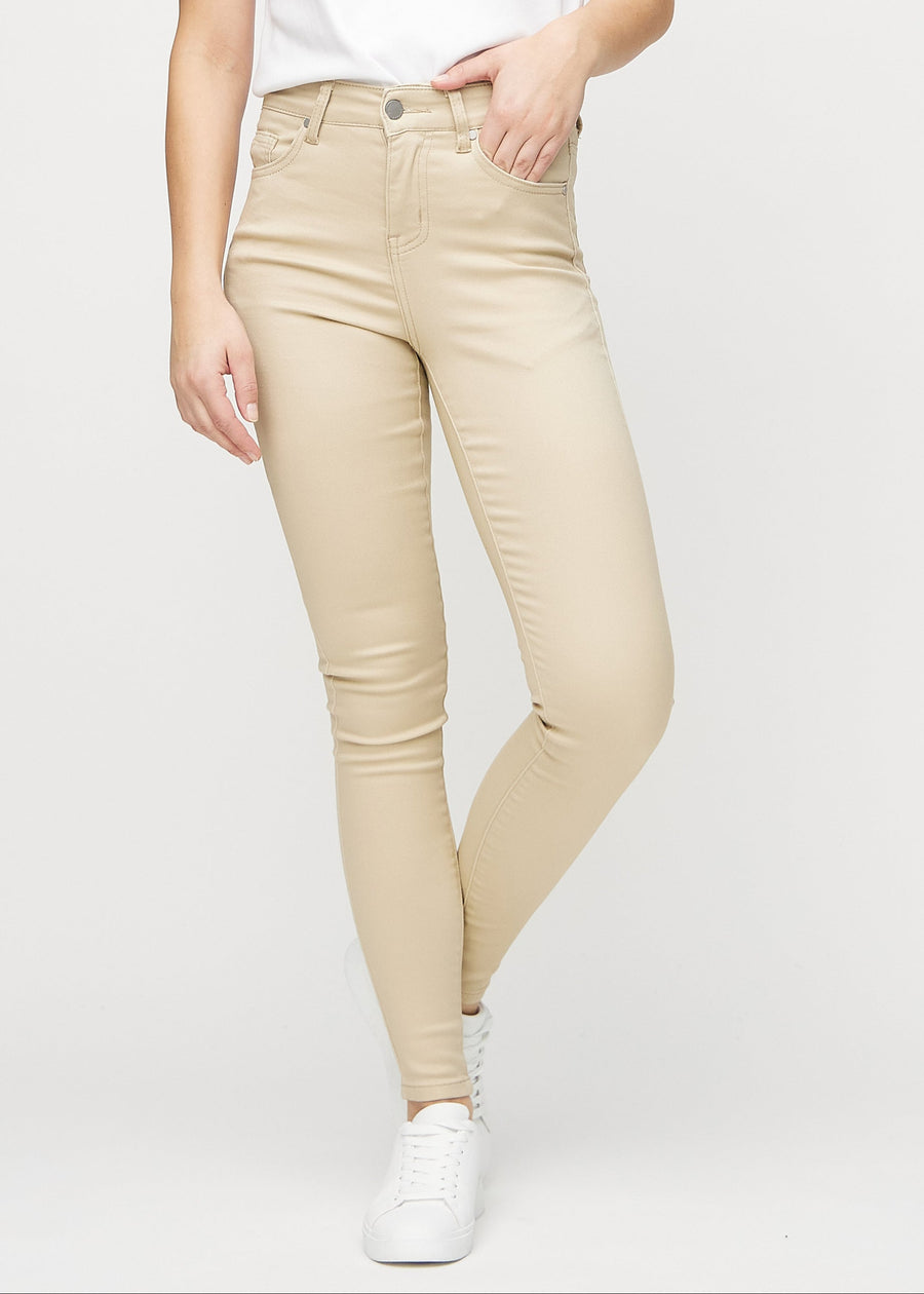 Skinnyjeans för kvinnor i beige, färgen Gazelles. Framifrån på en modell, med nära passform runt benen.