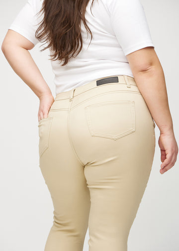 Skinnyjeans för kvinnor i beige, färgen Gazelles. Närbild bakifrån på en plus size-modell som visar detaljerna.
