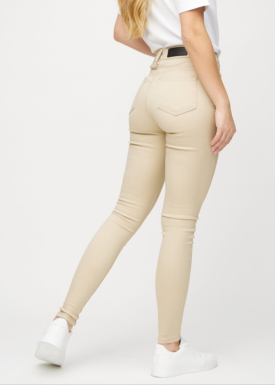 Skinnyjeans för kvinnor i beige, färgen Gazelles. Bakifrån på en modell, så att hela passformen syns.