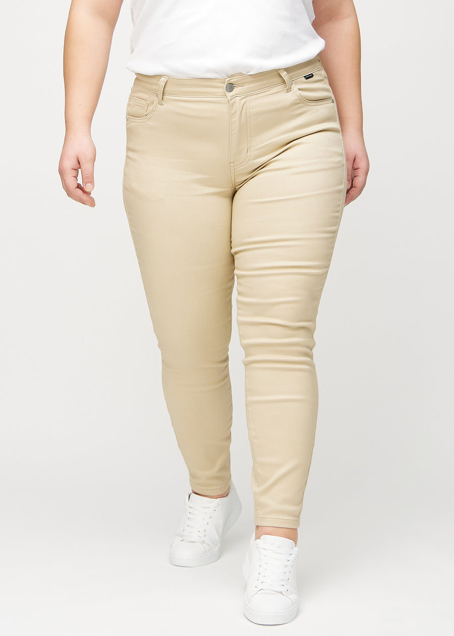 Skinnyjeans för kvinnor i beige, färgen Gazelles. Framifrån på en plus size-modell, med nära passform runt benen.