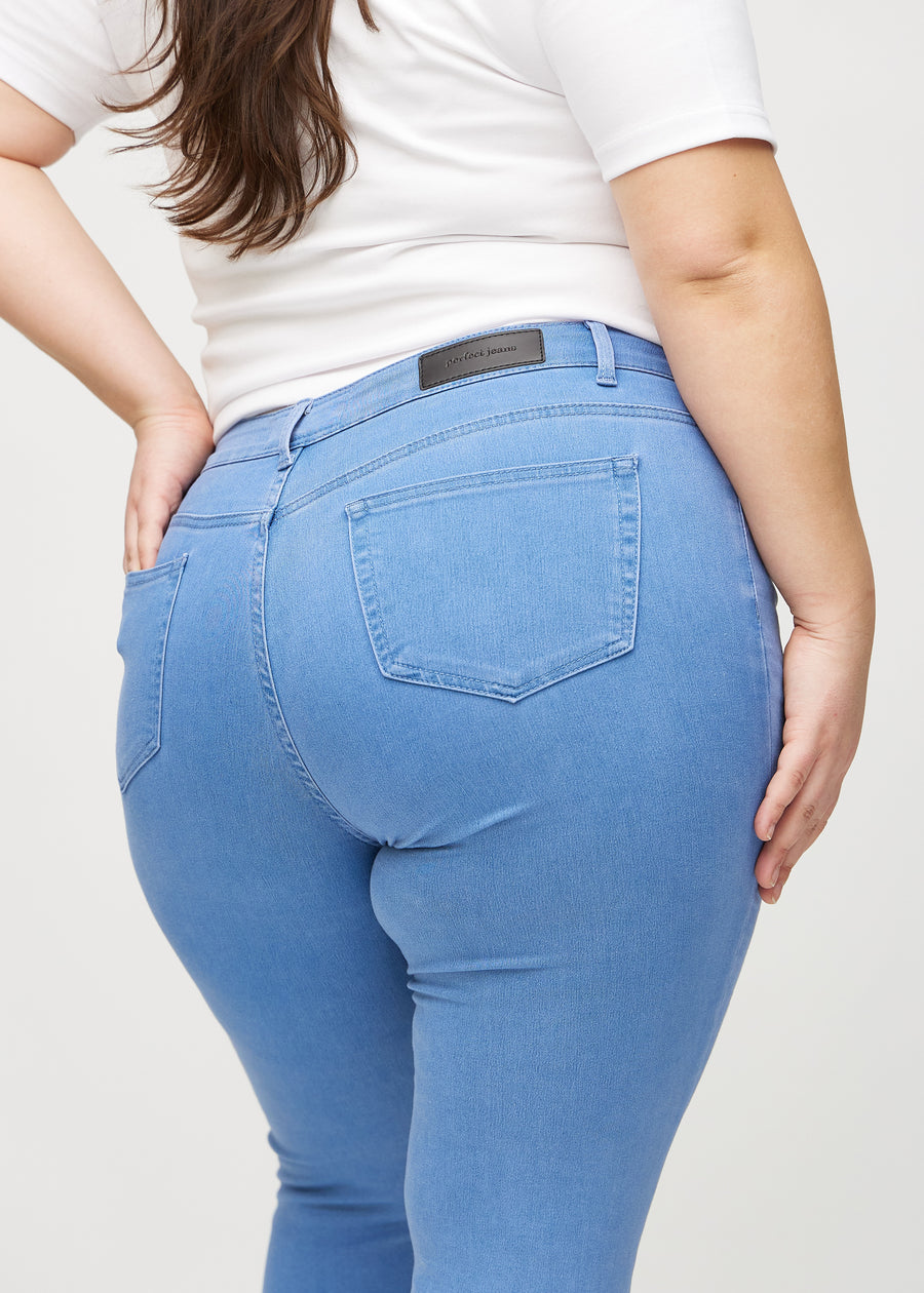 Skinnyjeans för kvinnor i blå, färgen Geraniums. Närbild bakifrån på en plus size-modell som visar detaljerna.