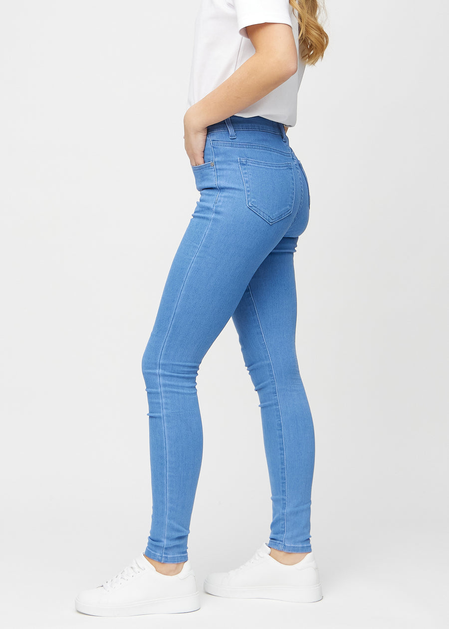 Skinnyjeans för kvinnor i blå, färgen Geraniums. Från sidan på en modell.