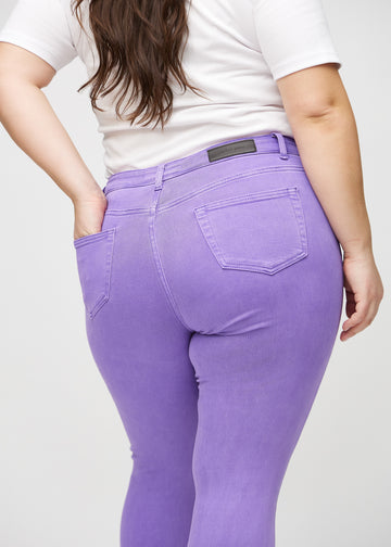 Skinnyjeans för kvinnor i lila, färgen Lavenders. Närbild bakifrån på en plus size-modell som visar detaljerna.