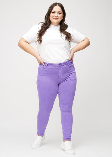 Skinnyjeans för kvinnor i lila, färgen Lavenders. Helbild av en plus size-modell i jeansen.