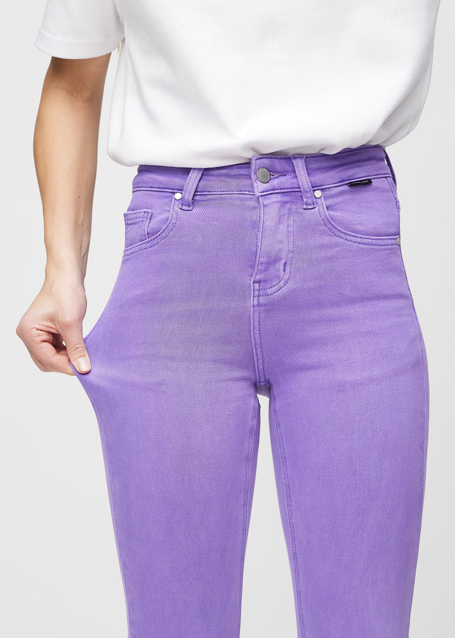 Skinnyjeans för kvinnor i lila, färgen Lavenders. En modell drar i jeanstyget vid låret för att visa stretchen.