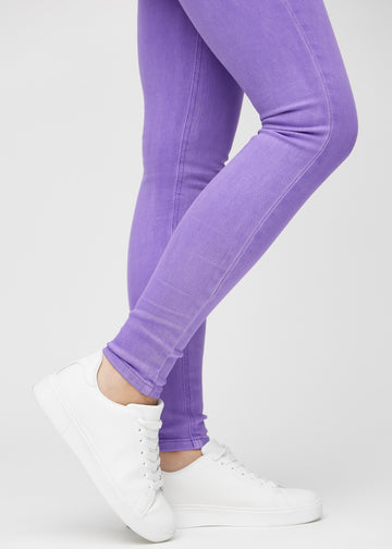 Skinnyjeans för kvinnor i lila, färgen Lavenders. Närbild vid anklarna på en modell som visar de åtsittande bensluten.