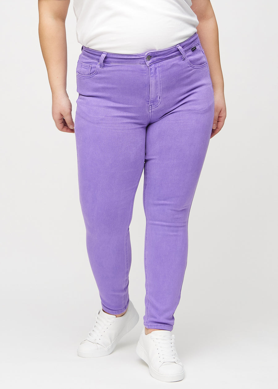Skinnyjeans för kvinnor i lila, färgen Lavenders. Framifrån på en plus size-modell, med nära passform runt benen.
