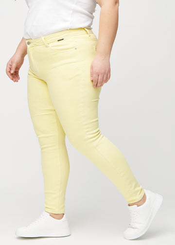 Skinnyjeans för kvinnor i ljusgul, färgen Lemonades. Från sidan på en plus size-modell.