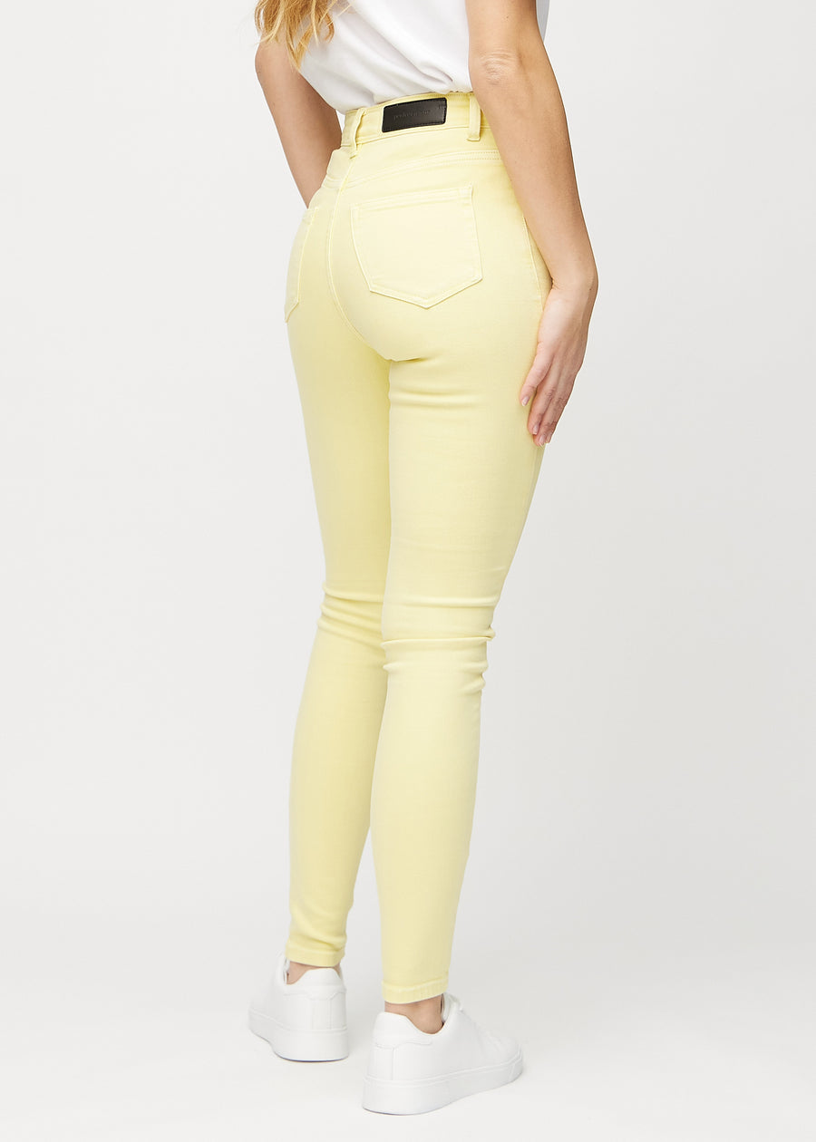 Skinnyjeans för kvinnor i ljusgul, färgen Lemonades. Bakifrån på en modell, så att hela passformen syns.