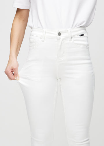 Skinnyjeans för kvinnor i vit, färgen Marguerites. En modell drar i jeanstyget vid låret för att visa stretchen.