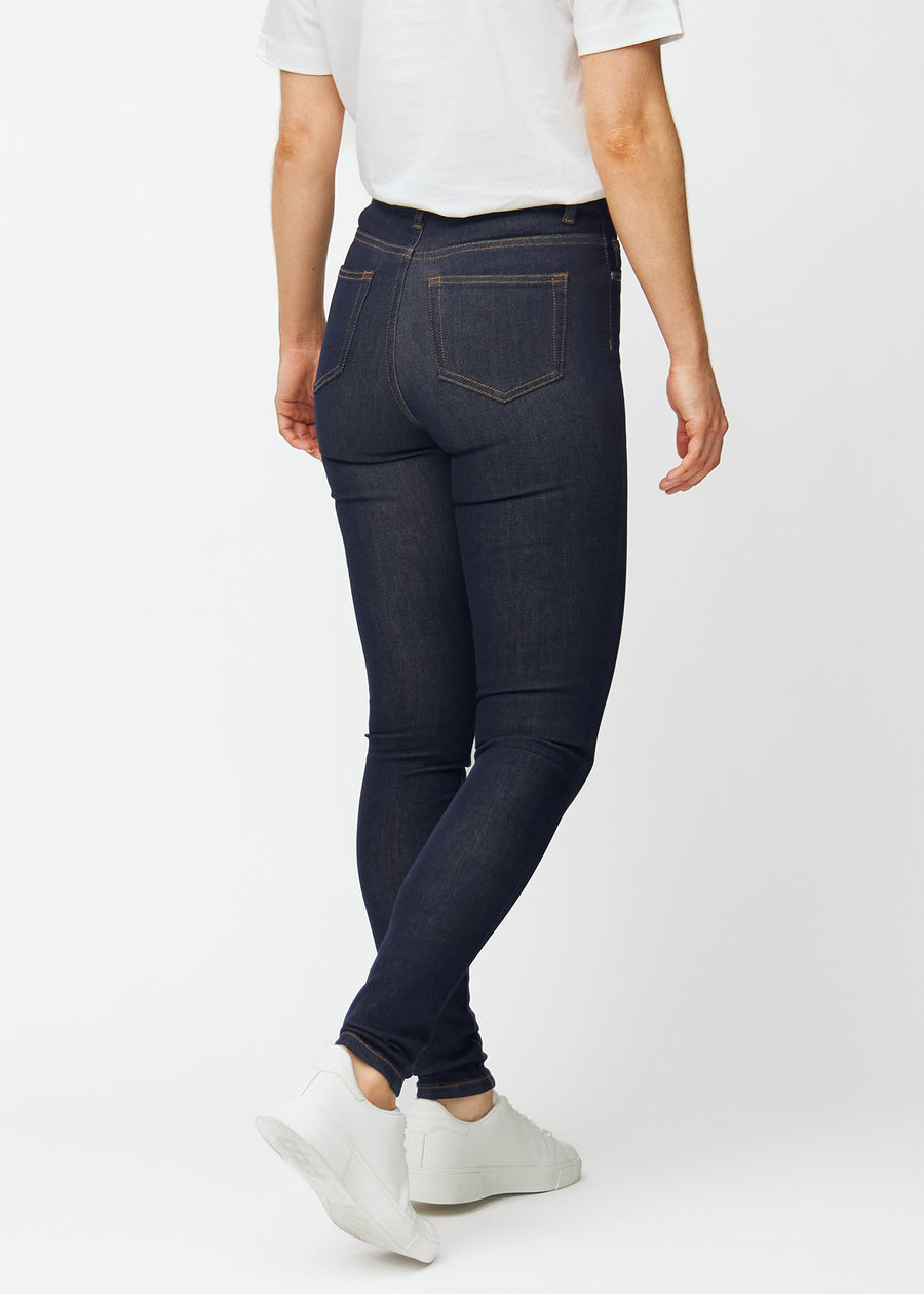 Djup mörkblå denim jeans för kvinnor i färgen Midnights sedd bakifrån, så att den tätsittande passformen kan ses.