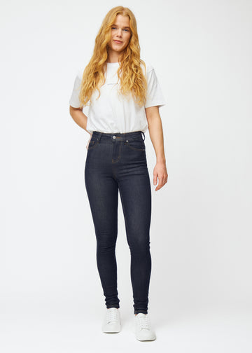 Helbild av modell i djup mörkblå denim jeans för kvinnor i färgen Midnights med skinny passform.