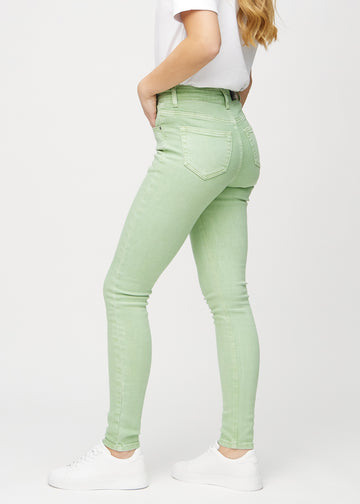 Ljusgröna skinny jeans sedda från sidan på modell.