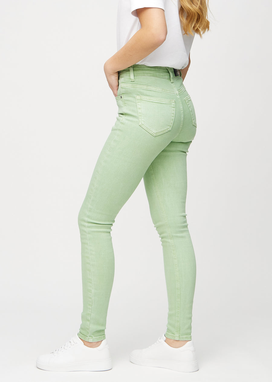Ljusgröna skinny jeans sedda från sidan på modell.