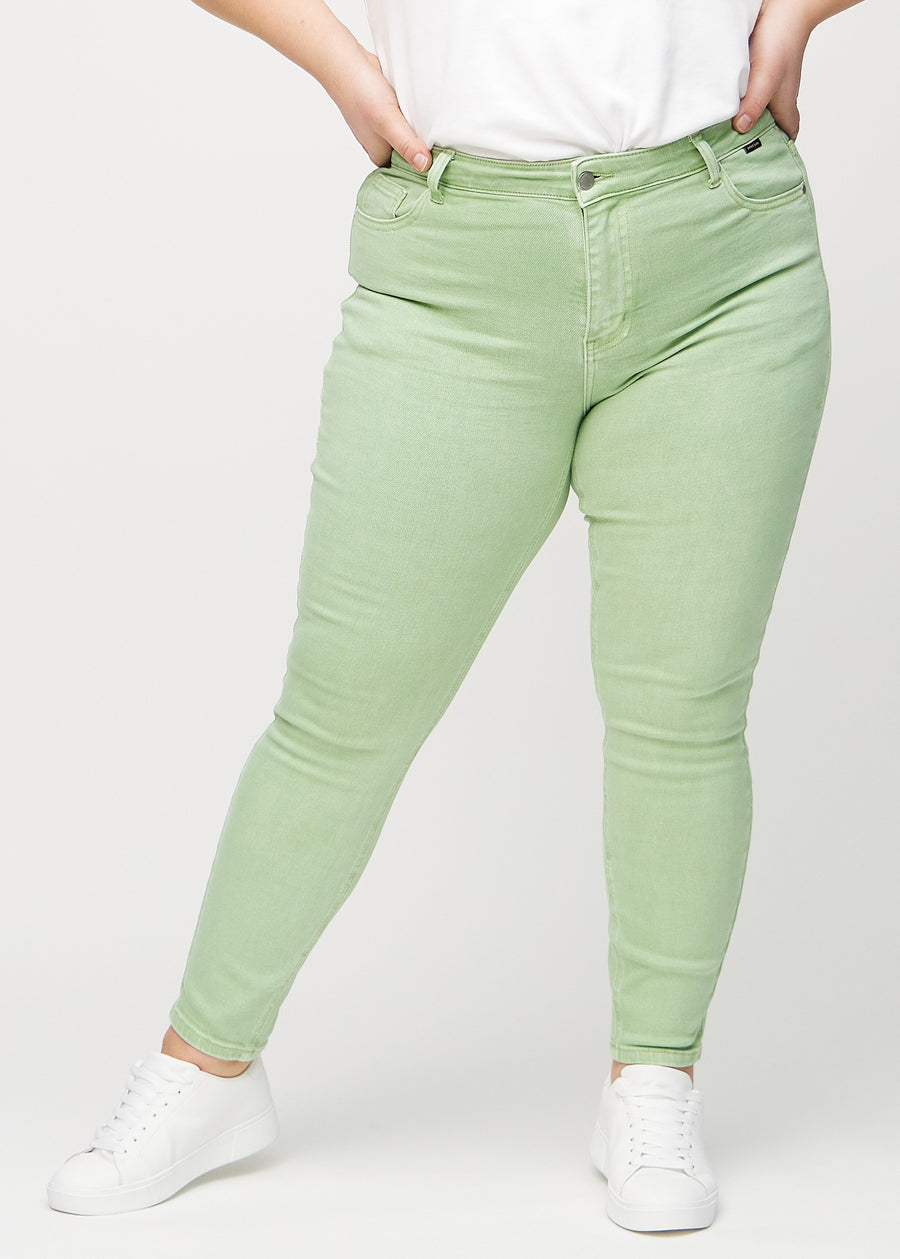 Ljusgröna skinny jeans, modellnamn Mints, som sitter tajt längs benet på en plus-size-modell, sedd framifrån.