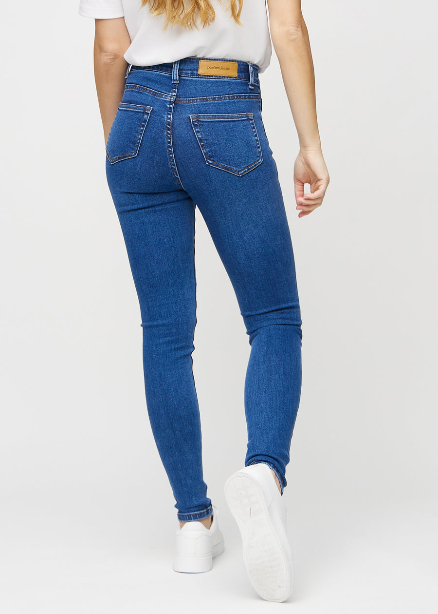 Skinnyjeans för kvinnor i mörkblå, färgen Oceans. Bakifrån på en modell, så att hela passformen syns.