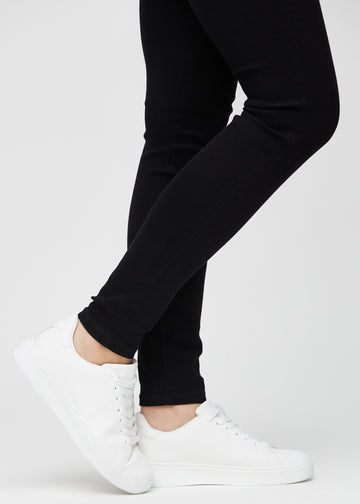 En modells anklar, så att man kan se hur tajt jeansen sitter i en Skinny passform.