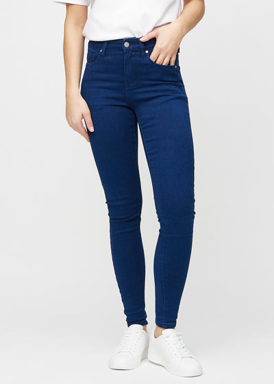 Skinnyjeans för kvinnor i mörkblå, färgen Royals. Framifrån på en modell, med nära passform runt benen.