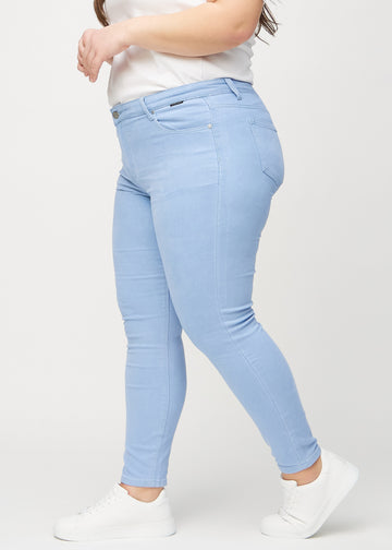 Skinnyjeans för kvinnor i ljusblå, färgen Skies. Från sidan på en plus size-modell.