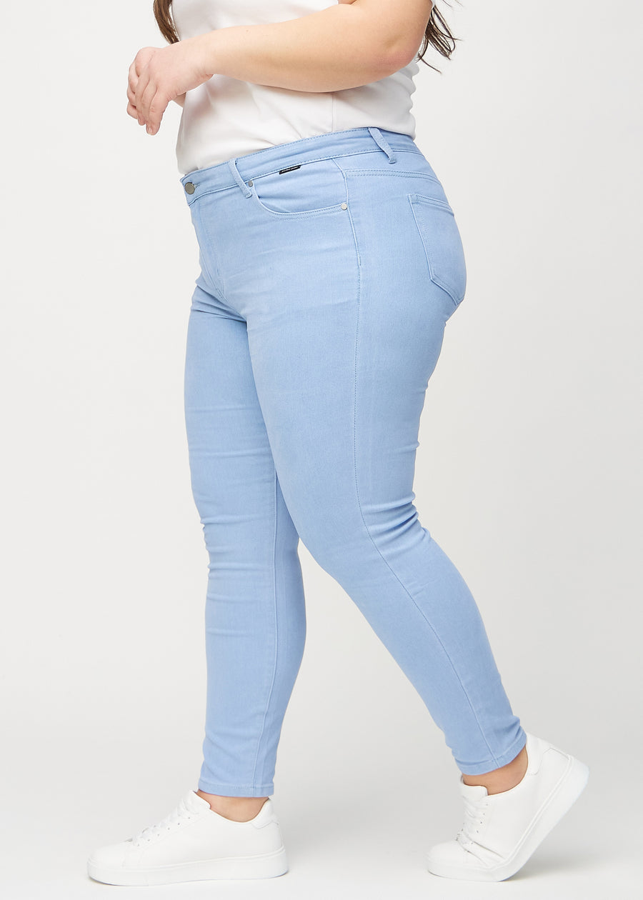 Skinnyjeans för kvinnor i ljusblå, färgen Skies. Från sidan på en plus size-modell.