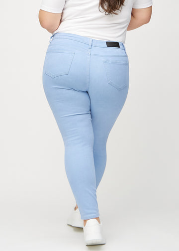 Skinnyjeans för kvinnor i ljusblå, färgen Skies. Bakifrån på en plus size-modell, så att hela passformen syns.