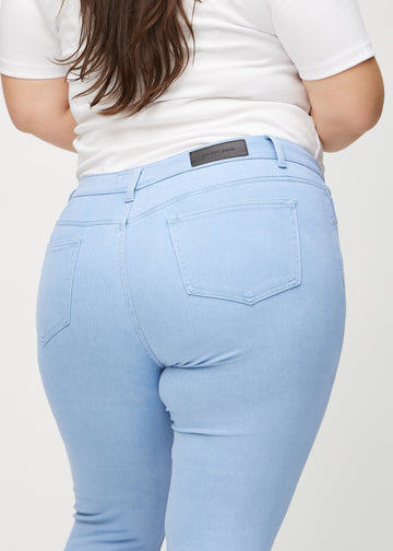 Skinnyjeans för kvinnor i ljusblå, färgen Skies. Närbild bakifrån på en plus size-modell som visar detaljerna.