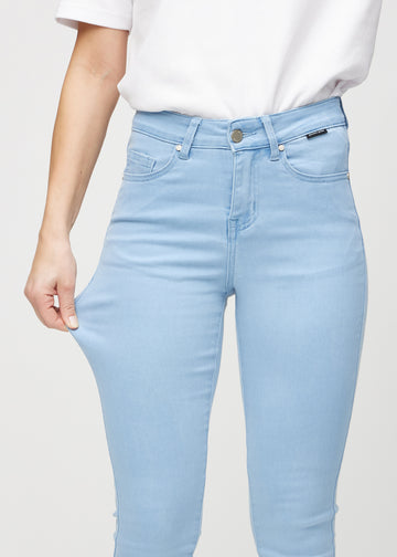 Skinnyjeans för kvinnor i ljusblå, färgen Skies. En modell drar i jeanstyget vid låret för att visa stretchen.