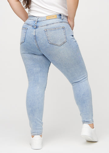 Skinnyjeans för kvinnor i ljusblå, färgen Waves. Bakifrån på en plus size-modell, så att hela passformen syns.